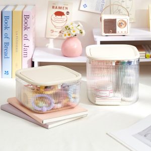 Hai hộp nhựa đựng phụ kiện và mỹ phẩm đặt trên bàn.