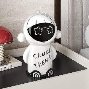 Thùng rác mini để bàn nhựa PP 5L hình hoạt hình đa năng cho gia đình Thùng rác mini màu trắng đặt trên kệ trang trí trong phòng.