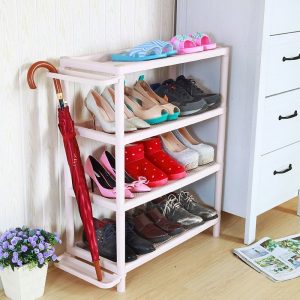 Kệ giày 4 tầng màu hồng nhạt, để sát tủ, chứa nhiều giày dép và ô dù.