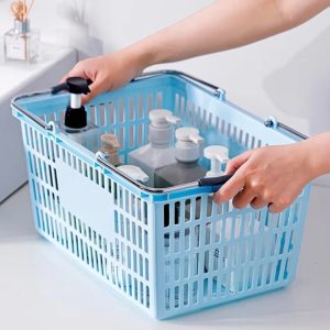 Hai tay cầm giỏ nhựa đựng nhiều chai lọ mỹ phẩm.