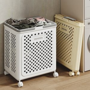 Hai giỏ đựng đồ giặt, một cái được gấp gọn sát tường, một cái đang sử dụng.