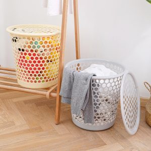 Hai giỏ đựng quần áo, một có nắp, một mở nắp, đựng quần áo và đồ dùng.