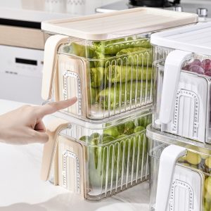 Người chỉ vào hộp nhựa nắp be, xếp chồng với hộp nắp trắng, đựng dưa leo