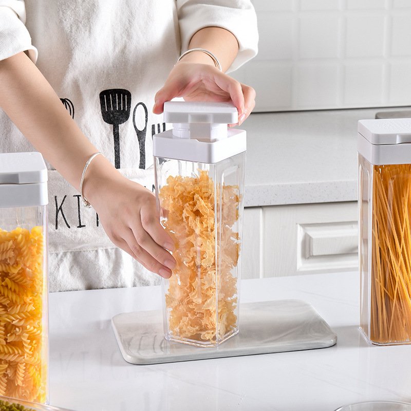 Hộp nhựa PP vuông kín khí đựng thực phẩm khô trong suốt tiện lợi Người đang đóng nắp hộp đựng thực phẩm chứa rong biển.