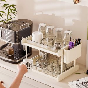 Kệ đựng cốc hai tầng với nhiều ly thủy tinh, có ngăn phụ bên hông đựng phụ kiện.
