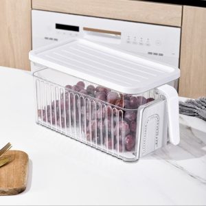Hộp nhựa nắp trắng trong suốt, đựng nho tím trên bàn bếp