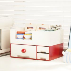 Hộp đựng đồ màu đỏ trắng đặt cạnh khung ảnh và máy pha cà phê.