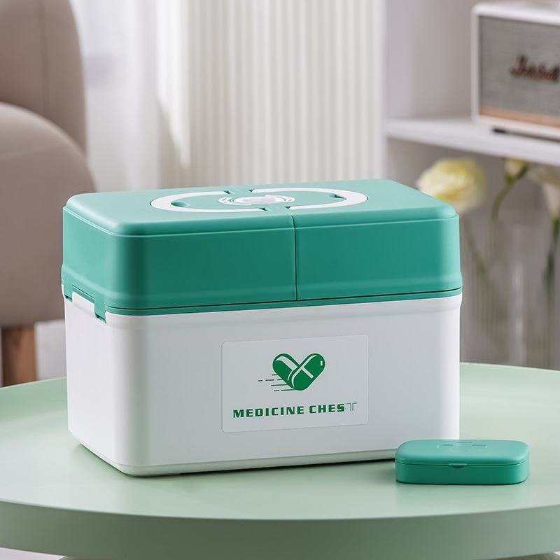 Hộp nhựa PP đựng thuốc y tế gia đình đa năng dung tích lớn tiện lợi Hộp y tế đặt trên bàn, bên cạnh là hộp chia thuốc nhỏ.